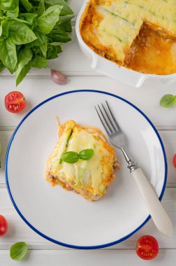 Beyaz ahşap bir zeminde tabak üzerinde sos bolonez soslu lezzetli kabak lazanyası. Sağlıklı yiyecekler. Üst Manzara. Seçici odak