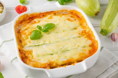 Beyaz ahşap bir kıyı şeridindeki fırında soslu bolonez soslu nefis kabak lazanyası. Sağlıklı yiyecekler. Üst Manzara. Seçici odak