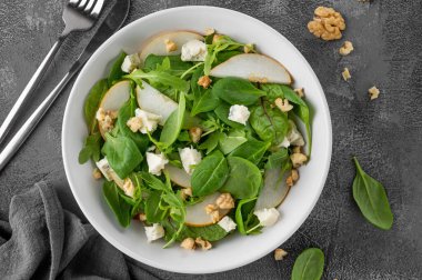 Ispanaklı salata, roka, taze armut, fındık ve zeytinyağlı Gorgonzola peyniri. Sağlıklı gıda konsepti