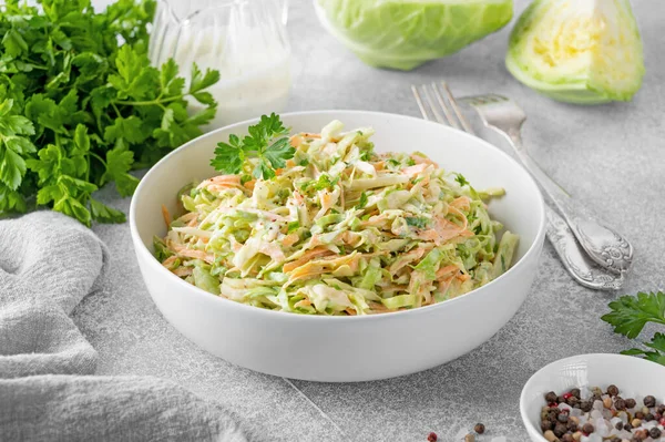 stock image Traditional cole slaw salad in a bowl on a gray concrete background. Salad with cabbage, carrot and mayonnaise sauce. Selective focus, copy space