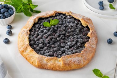 Yabanmersini galeti, açık turta ya da dondurmalı turta ve beyaz ahşap bir masada bir fincan çay. Yaz tatlısı