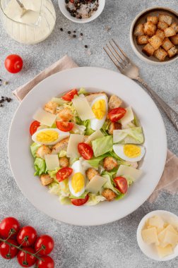 Marullu Sezar salatası, ızgara tavuk göğsü, haşlanmış yumurta, domates, parmesan peyniri ve çimento kaplı seramik tabakta kızarmış ekmek. Üst görünüm