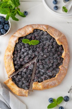 Yabanmersini galeti, açık turta ya da dondurmalı turta ve beyaz ahşap bir masada bir fincan çay. Yaz tatlısı