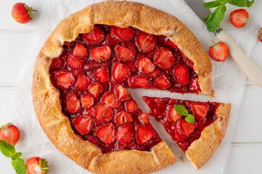 Galette, beyaz ahşap bir masada çilekli turta ya da turta. Yaz tatlısı