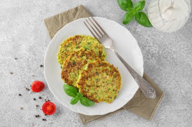 Beyaz bir tabakta taze fesleğen ve ekşi kremayla kabaklı börek ya da kabaklı gözleme. Üst görünüm, seçici odak