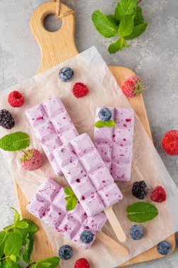 Ev yapımı böğürtlenli dondurma ya da gri beton arka planda nane yapraklı buzlu dondurma. Lezzetli yaz tatlıları, üst manzara.