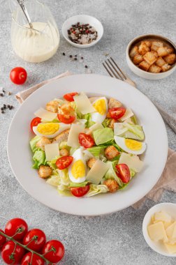 Marullu Sezar salatası, ızgara tavuk göğsü, haşlanmış yumurta, domates, parmesan peyniri ve çimento kaplı seramik tabakta kızarmış ekmek. Üst görünüm