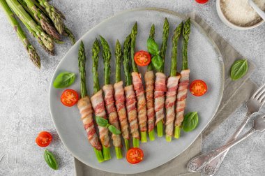 Pastırmalı ve parmesanlı peynirli fırında yeşil kuşkonmaz. Sağlıklı yiyecekler. Üst görünüm.