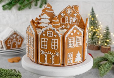 Beyaz pasta standında zencefilli ev kurabiyeleriyle süslenmiş ballı Noel pastası. Bayramlık tatlı. Seçici odak, boşluğu kopyala