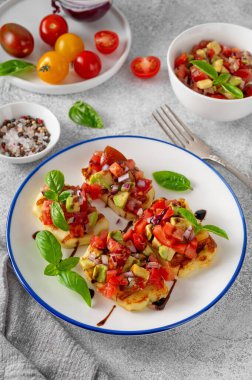 Izgara halloumi peyniri, domates, avokado, soğan ve balzamik soslu beton bir arka planda.