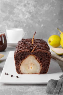 Çikolatalı turta ya da tam armutlu pasta ve gri arka planda çikolata jöleli pasta.