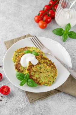 Beyaz bir tabakta taze fesleğen ve ekşi kremayla kabaklı börek ya da kabaklı gözleme. Üst görünüm, seçici odak