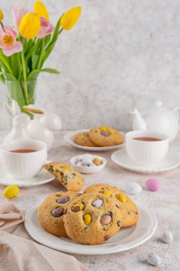 Paskalya kurabiyeleri. Geleneksel Amerikan kurabiyeleri çikolatalı mini yumurtalı beyaz tabakta şeker. Paskalya tatlısı. Boşluğu kopyala