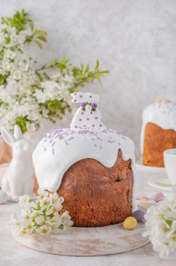 Paskalya tatlı ekmeği ya da Paskalya pastası - Şeker kaplı Paska, renkli şeker parçacıkları ve beton zemin üzerinde tahta bir tahtanın üstünde şeker tavşanı. Boşluğu kopyala