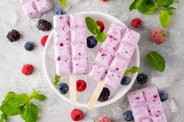 Ev yapımı böğürtlenli dondurma ya da gri beton arka planda nane yapraklı buzlu dondurma. Lezzetli yaz tatlıları, üst manzara.