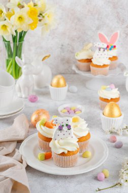 Paskalya çörekleri krema, şeker tavşancıkları, çikolata yumurtaları, jöleli havuçlarla süslenir. Paskalya yemeği kompozisyonu. Boşluğu kopyala