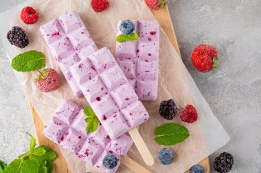 Ev yapımı böğürtlenli dondurma ya da gri beton arka planda nane yapraklı buzlu dondurma. Lezzetli yaz tatlıları, üst manzara.