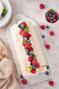 Kremalı kremalı kremalı pasta ve beton zemin üzerinde seramik bir tahtanın üzerinde taze böğürtlen. Boşluğu kopyala