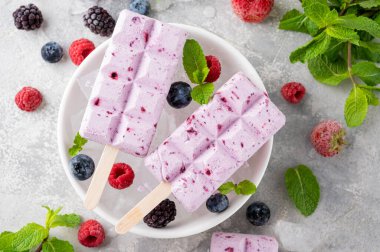 Ev yapımı böğürtlenli dondurma ya da gri beton arka planda nane yapraklı buzlu dondurma. Lezzetli yaz tatlıları, üst manzara.