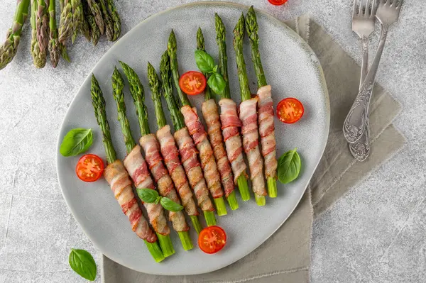 Pastırmalı ve parmesanlı peynirli fırında yeşil kuşkonmaz. Sağlıklı yiyecekler. Üst görünüm.