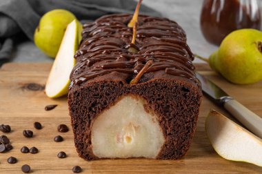 Çikolatalı turta ya da tam armutlu pasta ve gri arka planda çikolata jöleli pasta.