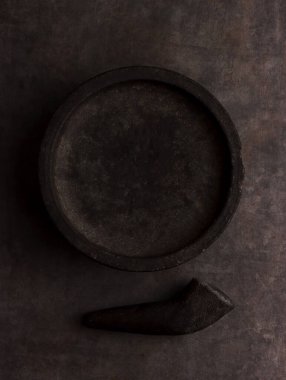 Havan tabanında Asya ürünleri fotoğraf otları aroma podyumu arka planda ahşap sahne zemininde siyah sanat eserlerini gösteriyor.