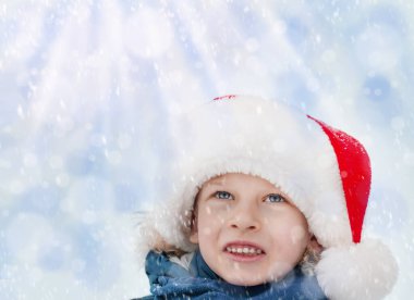 Noel Baba şapkalı bir çocuk düşen kara bakıyor. Yüksek kalite fotoğraf