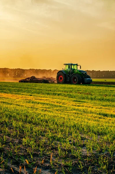 stock image tractor in the field under sunset light, tillage in spring. selective focus. High quality photo