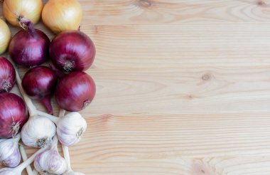 Tahta arka planda sarımsaklı kırmızı ve sarı soğanlar, hasat. Düz düzen, kopyalama alanı. Yüksek kalite fotoğraf