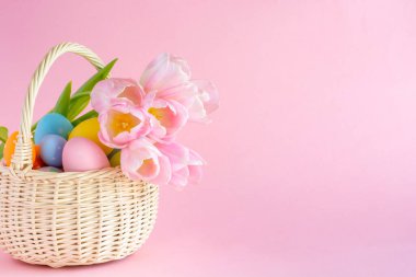 Paskalya yumurtaları ve pembe kağıtlı lalelerle dolu sepet, kopyalama alanı. Yüksek kalite fotoğraf