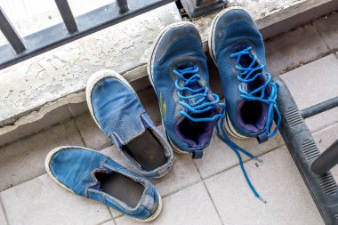 Bandung, Endonezya - 7 Haziran 2024: Eski, yıpranmış ayakkabılar: Lacoste ve Skechers. Ayakkabılar gözle görülür şekilde hasar görmüş, kirli ve yıpranmış, yoğun kullanımı ve zaman akışını yansıtıyor.