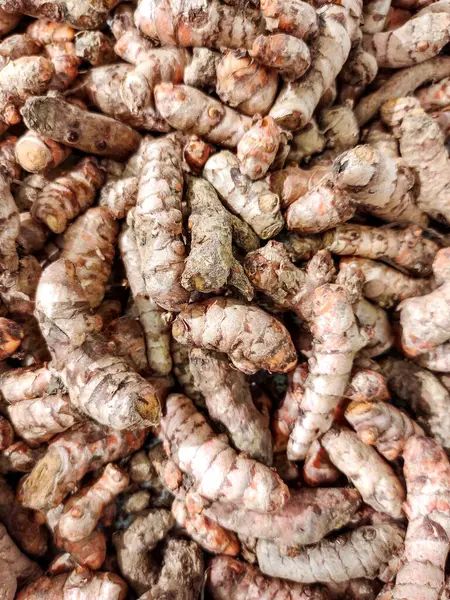 stock image A stack of turmeric or kunyit, a traditional spice commonly used in Asian, especially Southeast Asian, cuisine, displayed in a traditional market stall