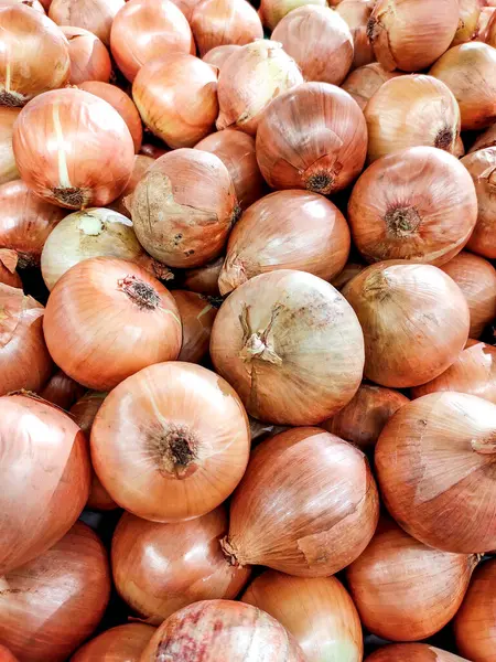 Geleneksel bir markette sergilenen taze soğan yığını. Soğanlar düzenli ve müşteriler için hazır.