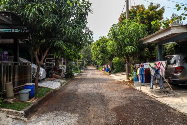 Cikarang, Endonezya - 2 Temmuz 2024: Tek Katlı Evler ve Lükslü Gölgeli Ağaçlar Konutları içinde sakin bir sokak manzarası