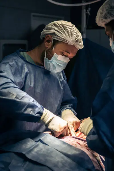 A team of doctors performing spine surgery on a patient with scoliosis inside the operating room.