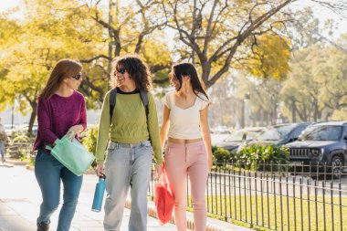 Güneşli bir günde üç kadından oluşan bir grup açık havada yürüyor, gülümsüyor ve temiz havanın tadını çıkarıyorlar, ellerinde tekrar kullanılabilir poşetler ve su şişeleri var. Birbirlerine bakıp komik bir anekdot anlatıyorlar..