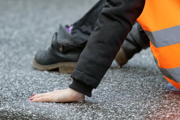 stock image a climate activist glued herself to the asphalt with superglue