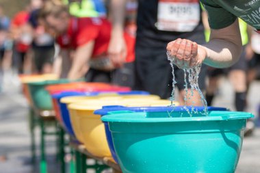 Hamburg maratonuna katılanlar plastik kaselerden gelen suyla kendilerini tazelerler.