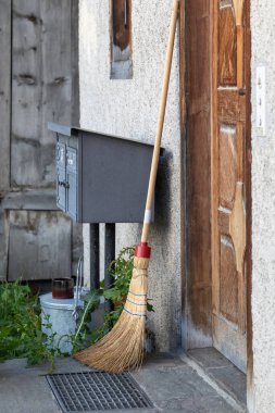 İsviçre köyündeki ön kapının önündeki süpürge.