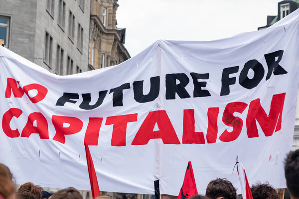 protesters carry banner against capitalism