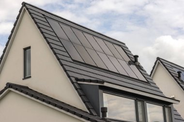 Noktalı gable ve güneş sistemiyle ayrılmış modern bir ev