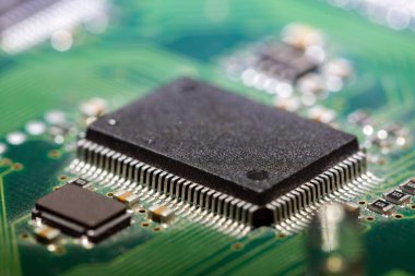 Yeşil devre kartındaki siyah bir bilgisayar çipinin makro görüntüsü