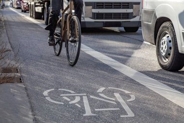 Bisikletçiler kamyonun yanında bisiklet sürüyor.