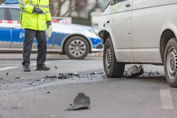 Polis memuru bir minibüsün kazasındaki hasarı inceliyor.