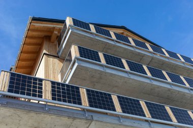 Residential building with large concrete balconies covered with solar cells clipart