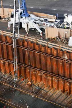 Büyük bir inşaat sahasında kamyon destekli beton pompa.