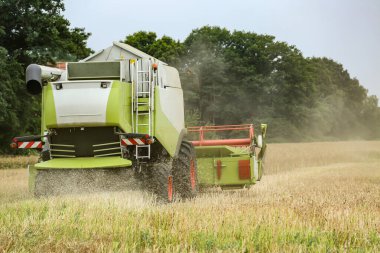 Tarlada büyük bir hasat makinası var.
