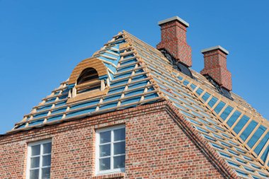 New building with clinker brick wall and roof battens for thatched roofing clipart