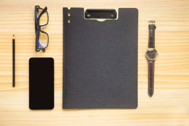 Bilgisayarlı ahşap masa ofisi, akıllı telefon ve bir fincan kahveyle birlikte diğer iş malzemeleri. Metni kopyalamak için üst görünümü kullan. Desenci çalışma alanı düz masa üzerinde temel elementler yatıyordu.