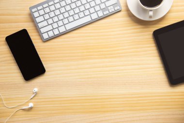 Bilgisayarlı ahşap masa ofisi, akıllı telefon ve bir fincan kahveyle birlikte diğer iş malzemeleri. Metni kopyalamak için üst görünümü kullan. Desenci çalışma alanı düz masa üzerinde temel elementler yatıyordu.